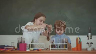 <strong>初中</strong>化学。 孩子们和老师在课堂上以黑板为背景学习。 学校化学课程